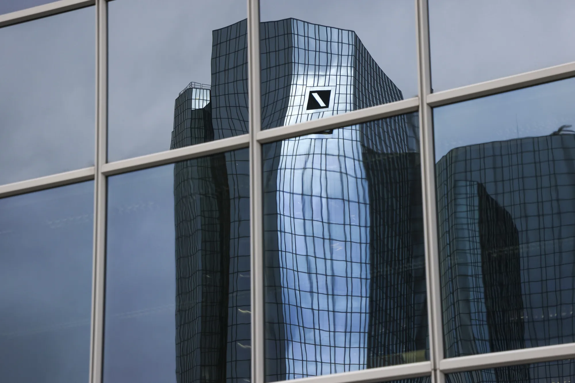 The headquarters of Deutsche Bank AG reflected in the windows of an office building in Frankfurt.