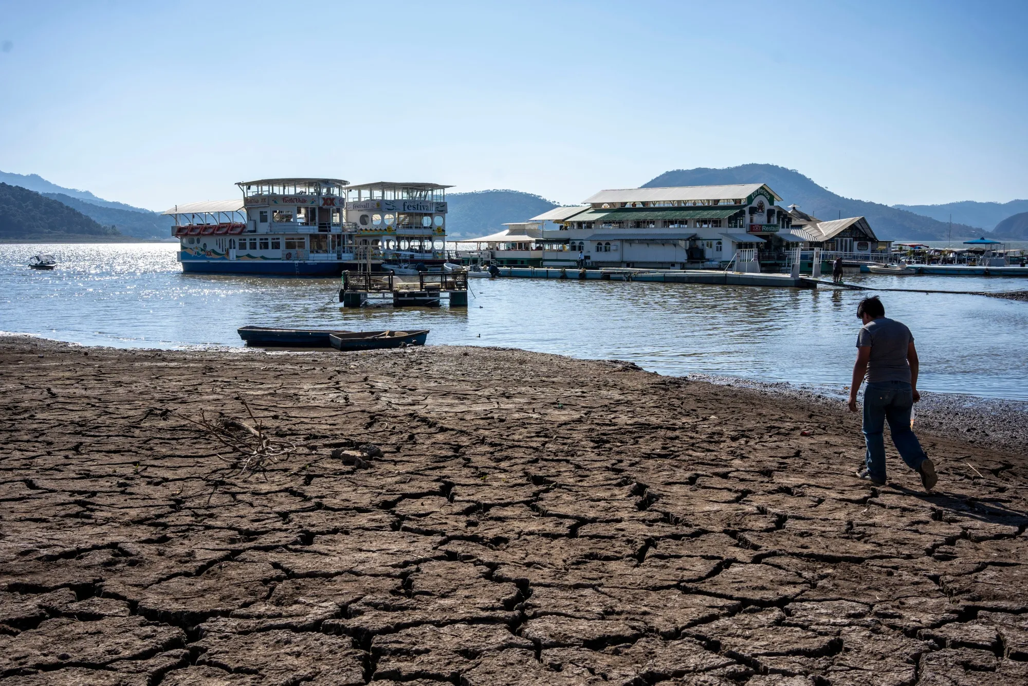 Lecho seco frente a restaurantes flotantes por estiaje en la presa Miguel Alemán durante sequía en Valle de Bravo.