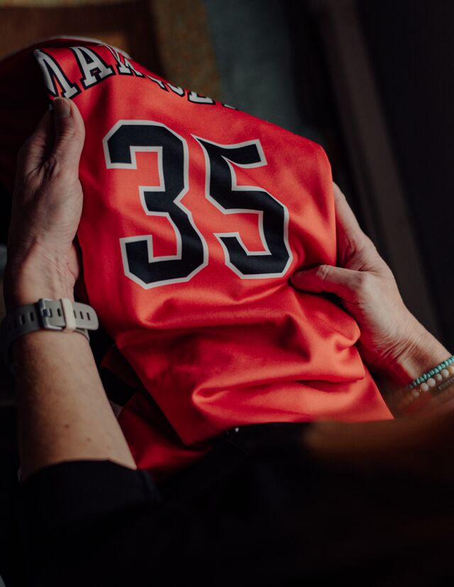 Jennifer Buta holds Jordan DeMay’s Marquette Senior High School jersey.