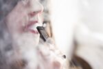 A person smokes a Juul&nbsp;e-cigarette.