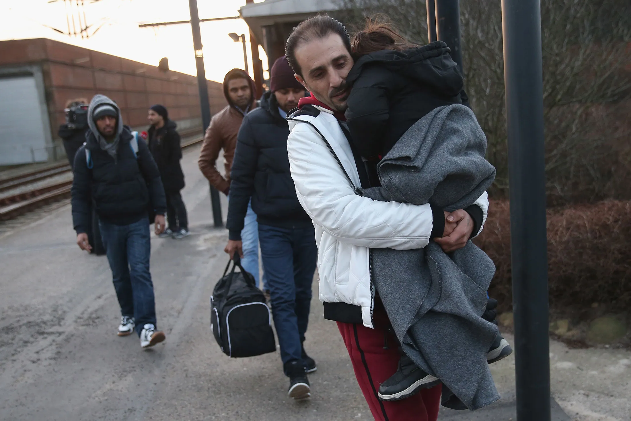 Migrants, many of them from Syria, walk to police vans after police found them while checking the identity papers of passengers on a train arriving from Germany on Jan. 6, in Padborg, Denmark.
