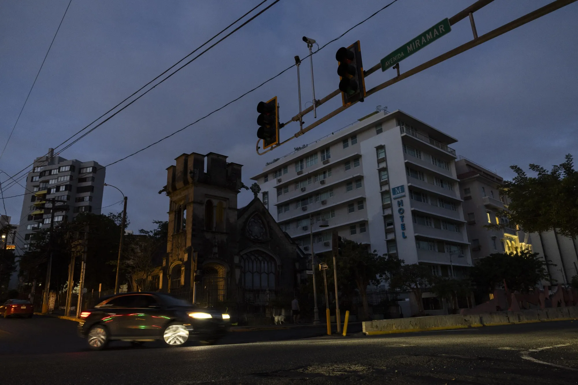 A vehicle at an intersection without functioning stop lights during a power outage in San Juan.