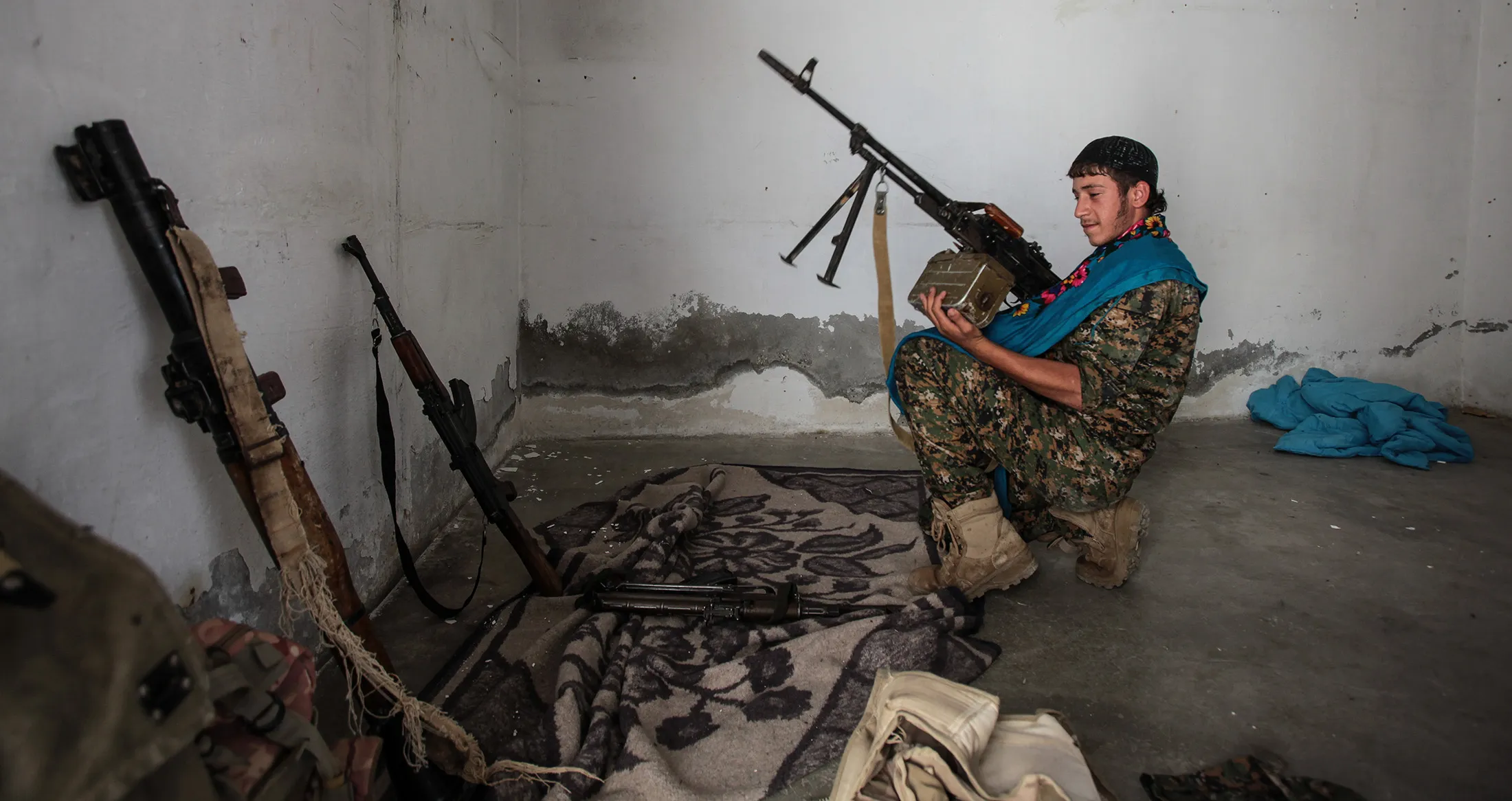 A Kurdish fighter handles a weapon in Tal Abyad, Syria.
