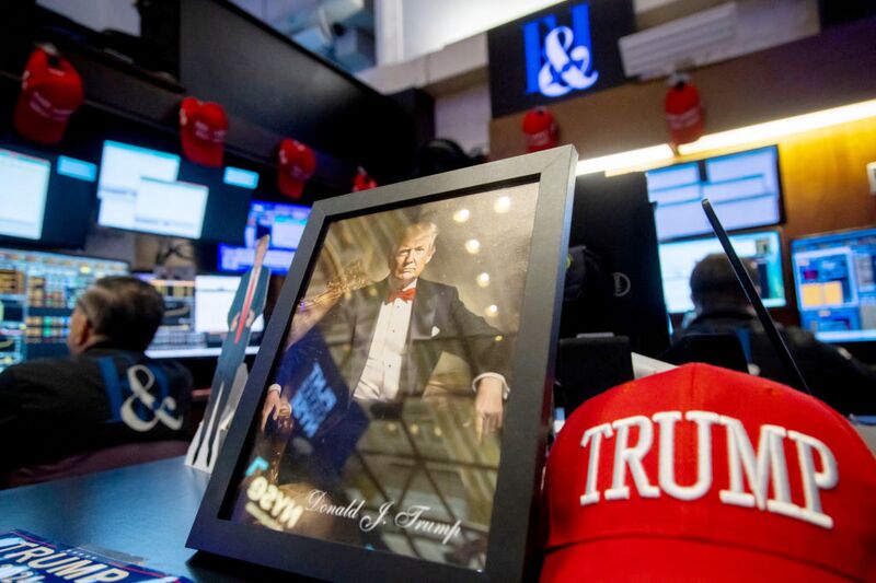 An image of US President-elect Donald Trump next to a "Trump" hat on the floor of the New York Stock Exchange (NYSE) in New York, US, on Tuesday, Dec. 31, 2024. US stocks dropped during the last trading session of an otherwise stellar year as investors ponder the monetary policy outlook for 2025.