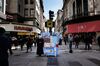 Pedestrians walk past a vendor selling Argentine flag souvenirs on the street in Buenos Aires, Argentina, on Tuesday, Aug. 13, 2019. In the wake of President Mauricio Macri's stunning rout in primary elections over the weekend, investors dumped its stocks, bonds and currency en masse, leaving much of Wall Street wondering whether the country was headed for yet another default.