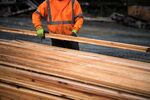 A worker stacks freshly cut boards at a sawmill in Sooke, British Columbia, Canada.
