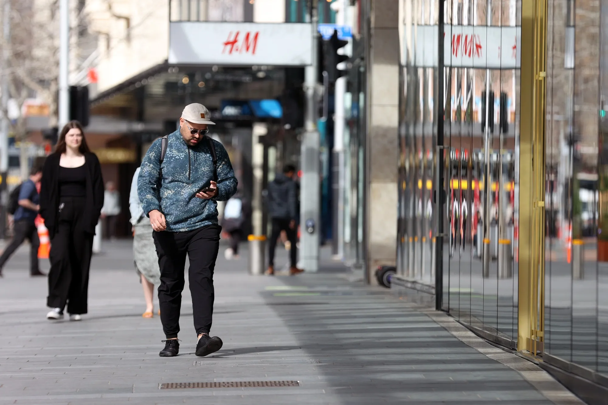 Shoppers walk past stores in Auckland, New Zealand, on Tuesday, Sept. 13, 2022.&nbsp;