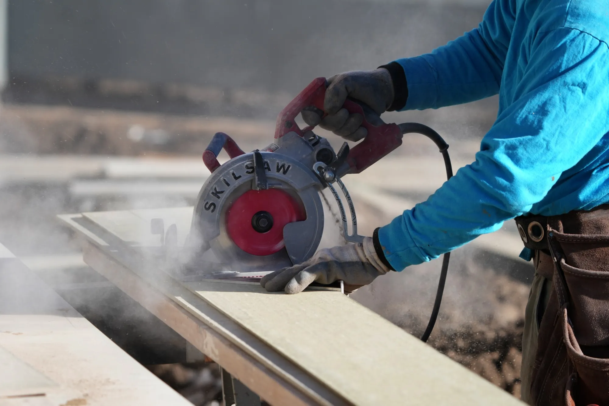 A worker prepares siding to install on a single family home under construction in Lehi, Utah.