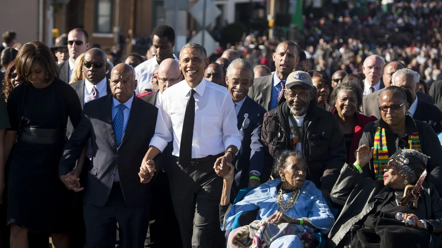 US President Barack Obama walks alongside Amelia Boynton Robinson (2nd-R), one of the original marchers, First Lady Michelle Obama (L), and US Representative John Lewis (2nd-L), Democrat of Georgia, and also one of the original marchers, across the Edmund Pettus Bridge to mark the 50th Anniversary of the Selma to Montgomery civil rights marches in Selma, Alabama, March 7, 2015. The event commemorates Bloody Sunday, when civil rights marchers attempting to walk to the Alabama capital of Montgomery to end voting discrimination against African Americans, clashed with police on the bridge. AFP PHOTO / SAUL LOEB
