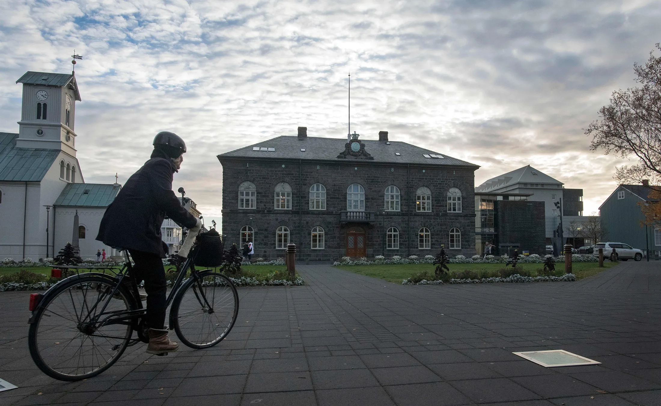 A woman cycles past the Althingi Parliament building in Reykjavik.