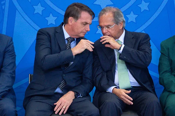 BRASILIA, BRAZIL - FEBRUARY 20: President of Brazil Jair Bolsonaro talks with Brazil's Economy Minister Paulo Guedes during the "Ceremony of the New Housing Credit Program" at the Planalto Palace on February 20, 2020 in Brasilia, Brazil. (Photo by Andressa Anholete/Getty Images)