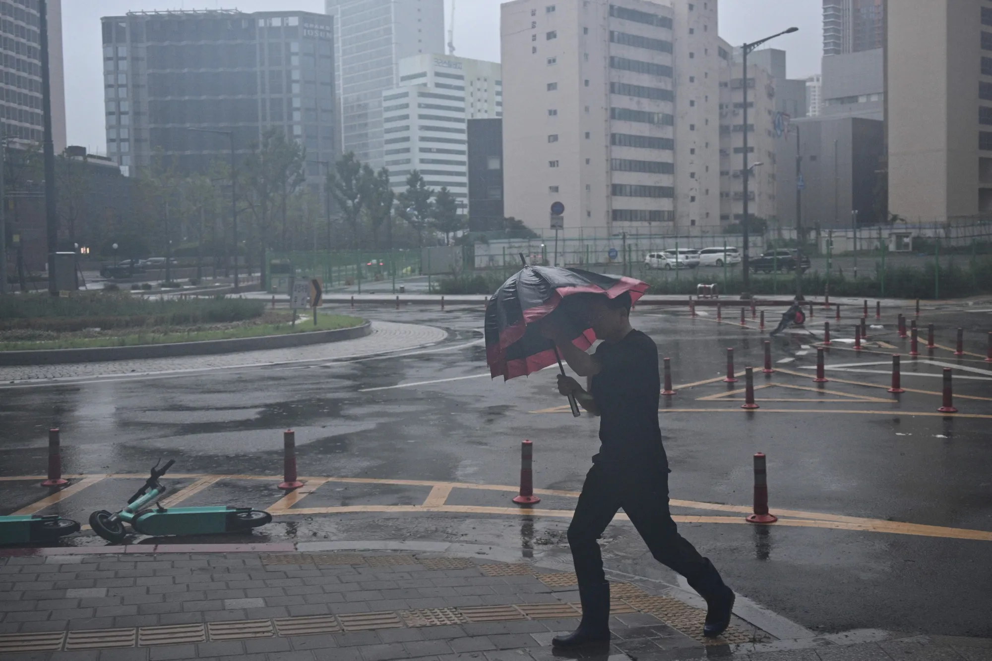 A man uses his umbrella in the southeastern port city of Busan, as Typhoon Khanun approaches, on Aug. 10.