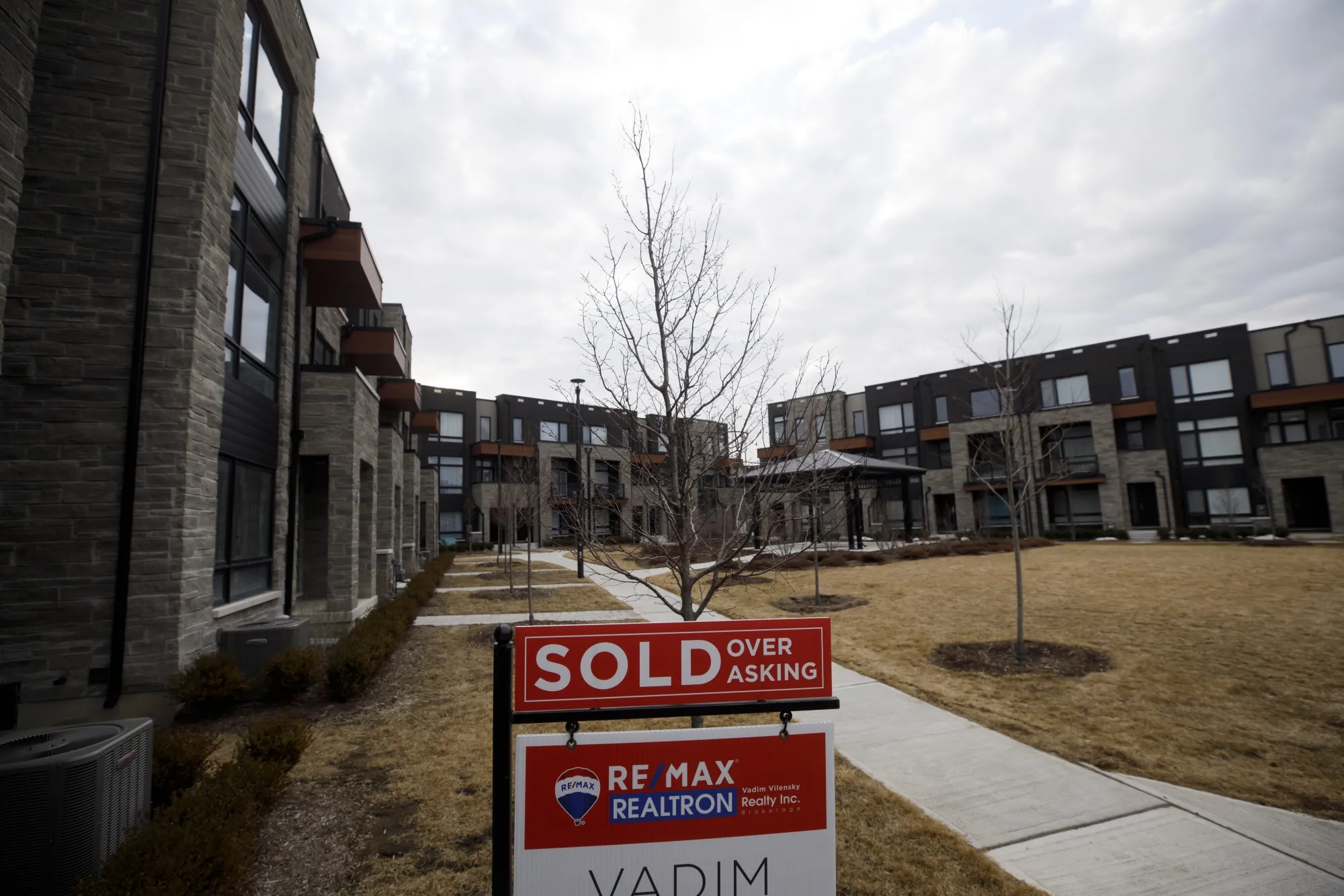 A "Sold" sign in front of a row of homes in a subdivision in Vaughan, Ontario, Canada, on Thursday, March 11, 2021. The buying, selling and building of homes in Canada takes up a larger share of the economy than it does in any other developed country in the world, according to the Bank of International Settlements, and also soaks up a larger share of investment capital than in any of Canada’s peers.