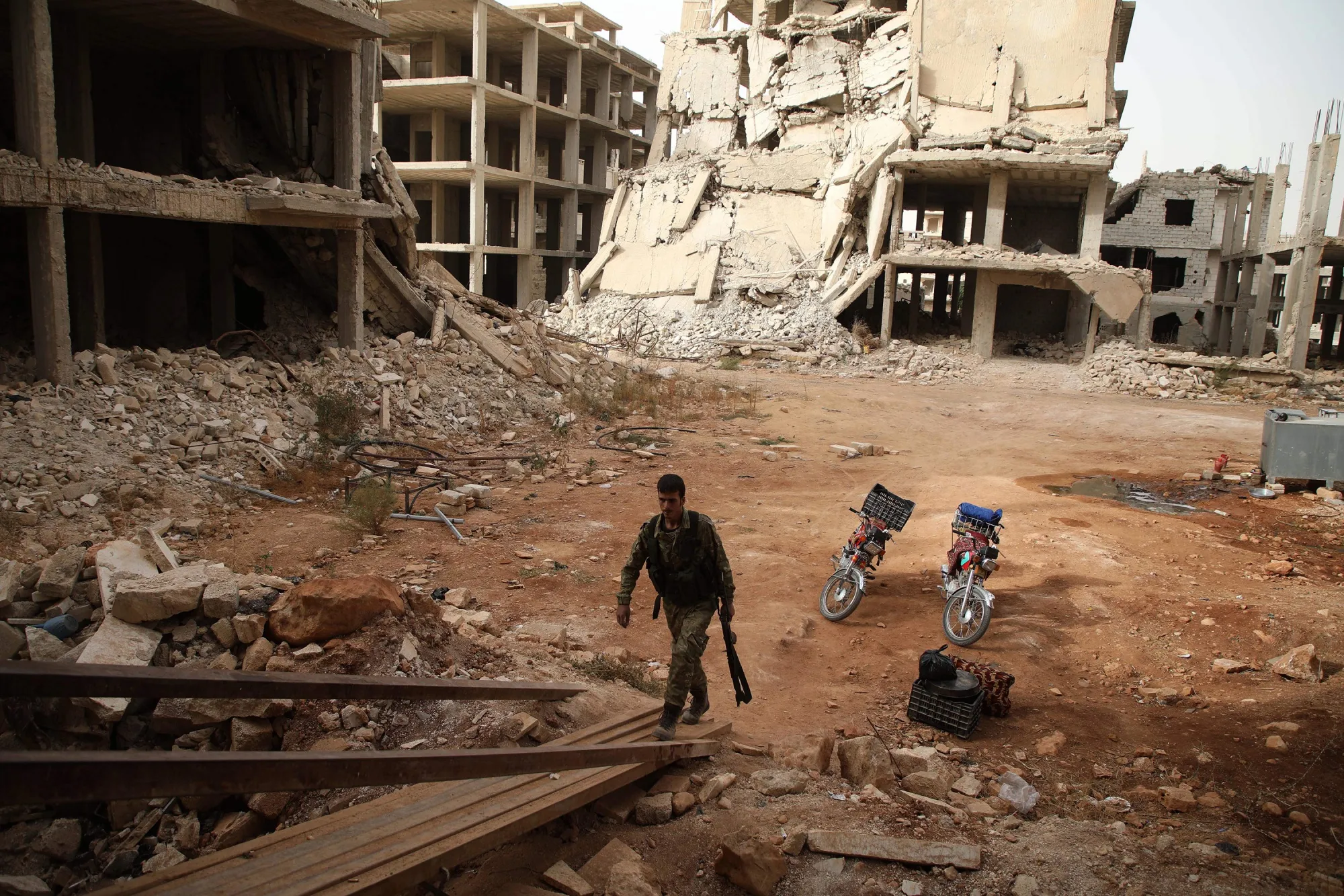 A Syrian rebel-fighter&nbsp;enters a building in the rebel-held al-Rashidin district of western Aleppo's countryside near Idlib province.