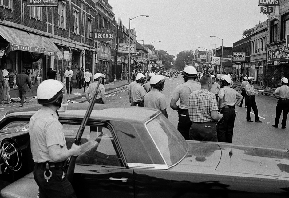 Police blockade a street on Detroit's Near West Side, about three miles from the downtown area, throwing stones and bottles at store fronts, and looting, July 23, 1967. Violence erupted early Sunday morning when police raided an unlicensed after-hours bar known as a &quot;blind pig&quot;.