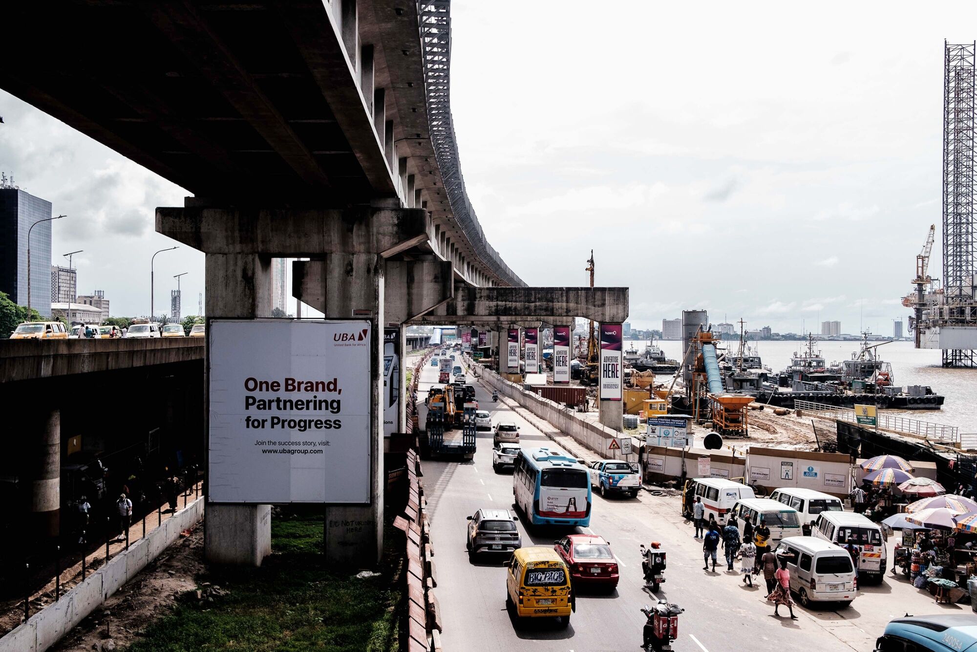 Vehicles and construction crews working along the CMS corridor in Lagos, a busy commercial and transport area by the waterfront.