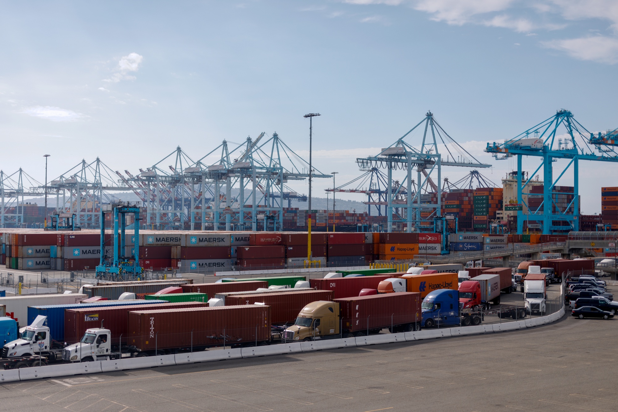 Tractor trailers carrying shipping containers at the Port of Los Angeles.