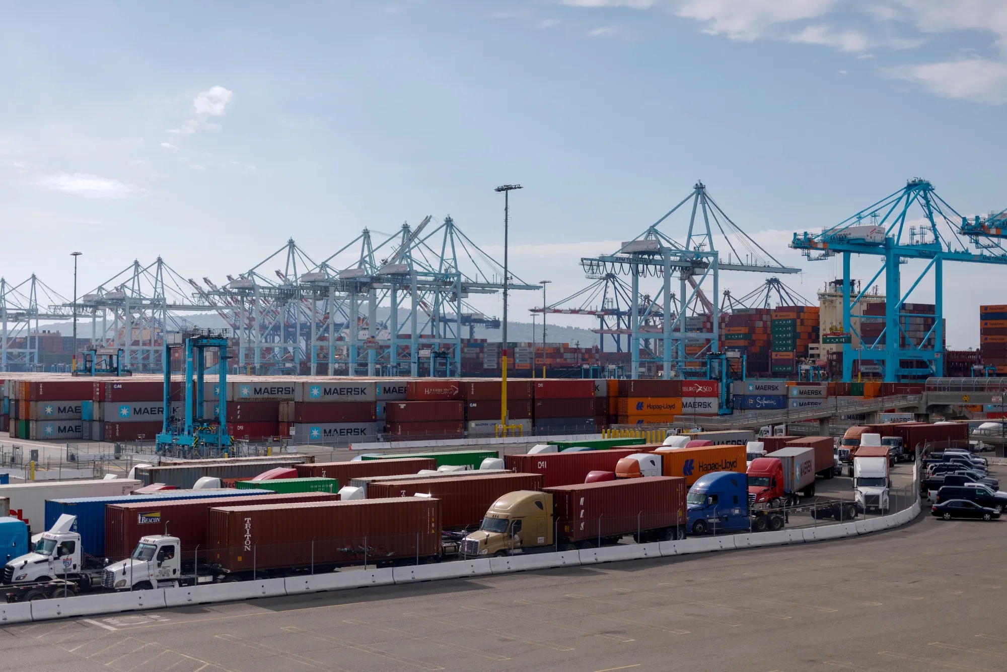 Tractor trailers carrying shipping containers at the Port of Los Angeles.