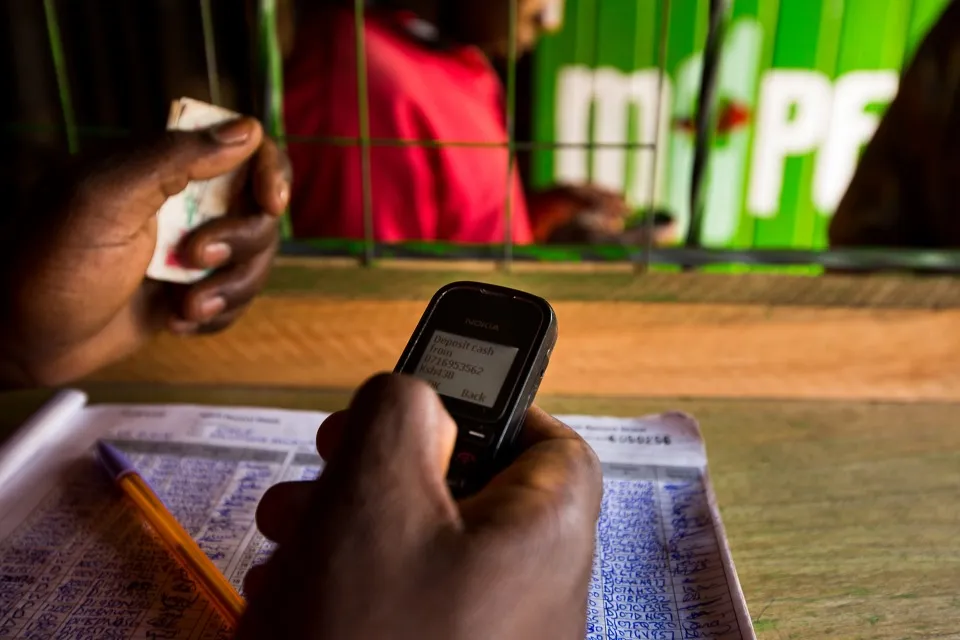 An employee uses a mobile phone for&nbsp;money transfer&nbsp;inside an M-Pesa store in Nairobi, Kenya.