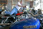 Ron Dallin sits on a Harley Davidson motorocycle at the Timpanagos Harley-Davidson showroom in Lindon, Utah, U.S., on Wednesday, July 15, 2009. Harley-Davidson Inc., the biggest U.S. motorcycle maker, said second-quarter profit fell 91 percent and it is cutting output and another 1,000 jobs as the recession curbs sales.