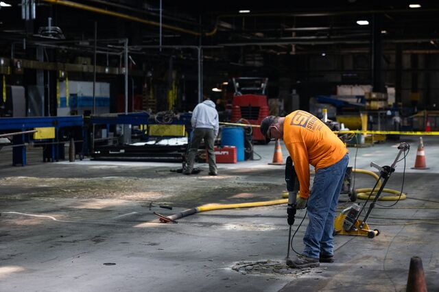 Workers drill the cement floor during renovations at the Scranton Army Ammunition Plant.