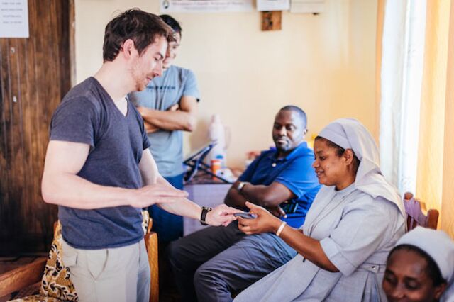 A health worker in Rwibaale Uganda practicing using Simprints to enroll Toby using his fingerprint.