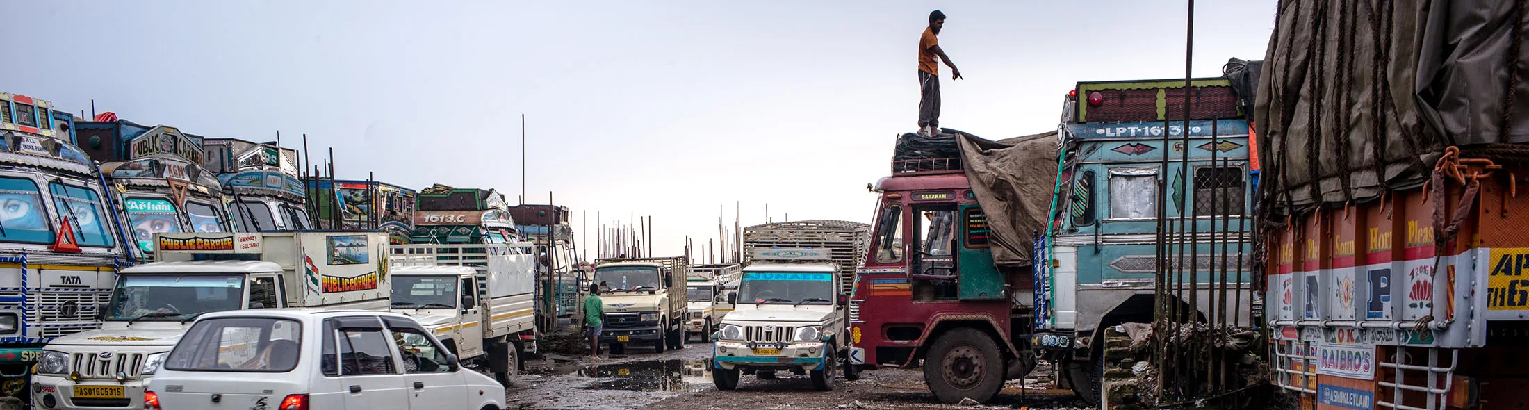 A worker standing on the roof of a truck is reflected in a large puddle at a truck stop at the Bara Bazar market in Shillong, Meghalaya, India, on Tuesday, Aug. 16, 2016. Indian state-run banks bought a record amount of sovereign bonds Monday after a selloff following the naming of Urjit Patel as the next central bank governor pushed yields to the highest in almost seven months.
