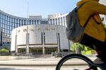 A person rides a bike past the PBoC.
