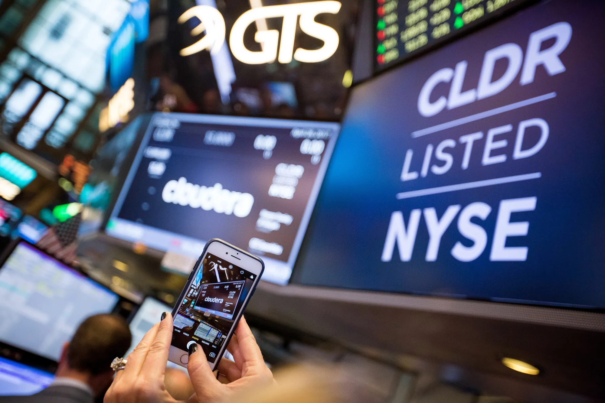 A person takes a photograph&nbsp;of Cloudera Inc. signage during the company's IPO on the of the NYSE in 2017.&nbsp;
