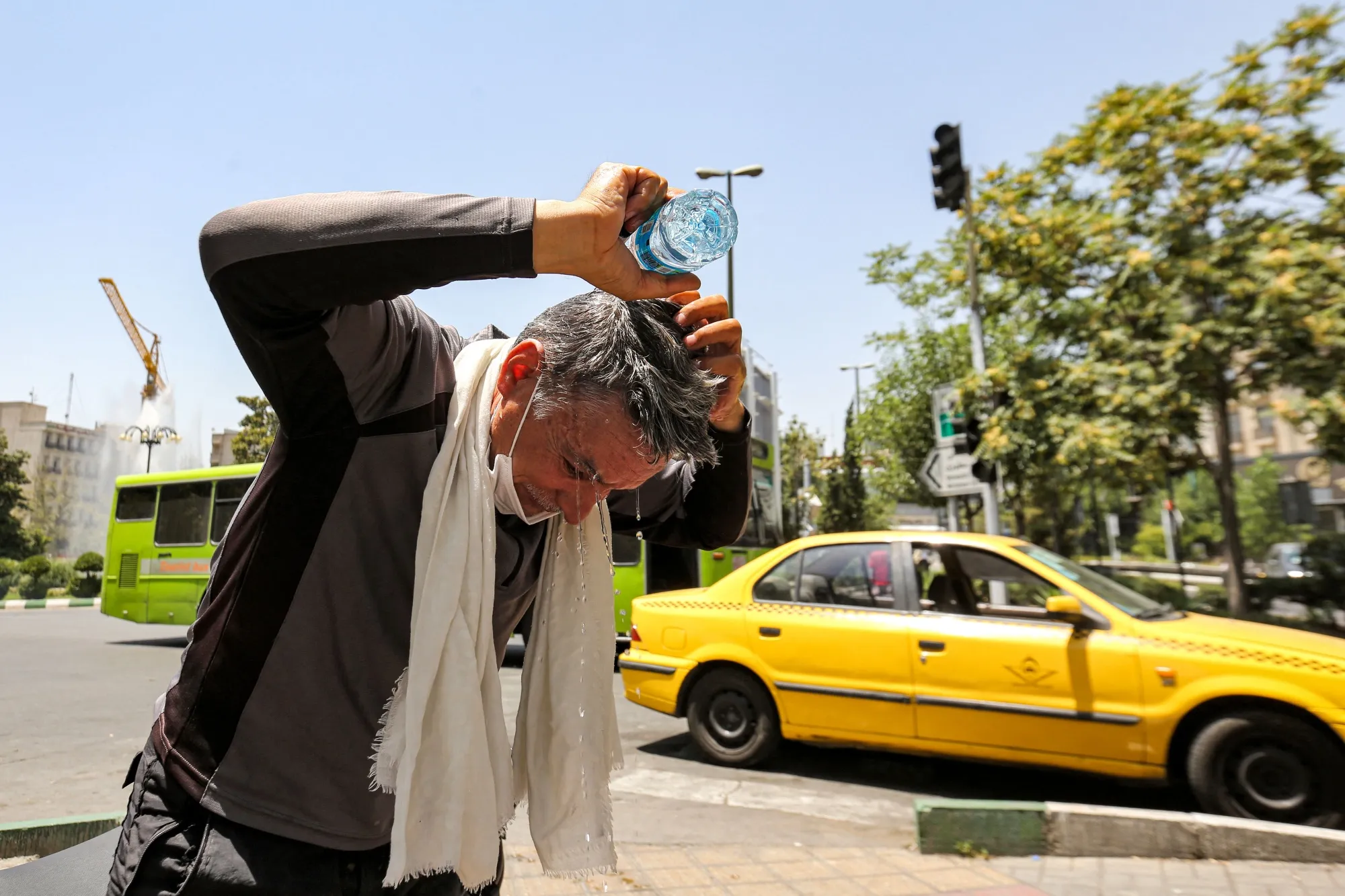 A man pours water on his head to cool off during a heat wave in Tehran in July.