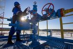 A worker turns a valve wheel at a gas well on the Gazprom oil, gas and condensate field in the Lensk district of the Sakha Republic, Russia.