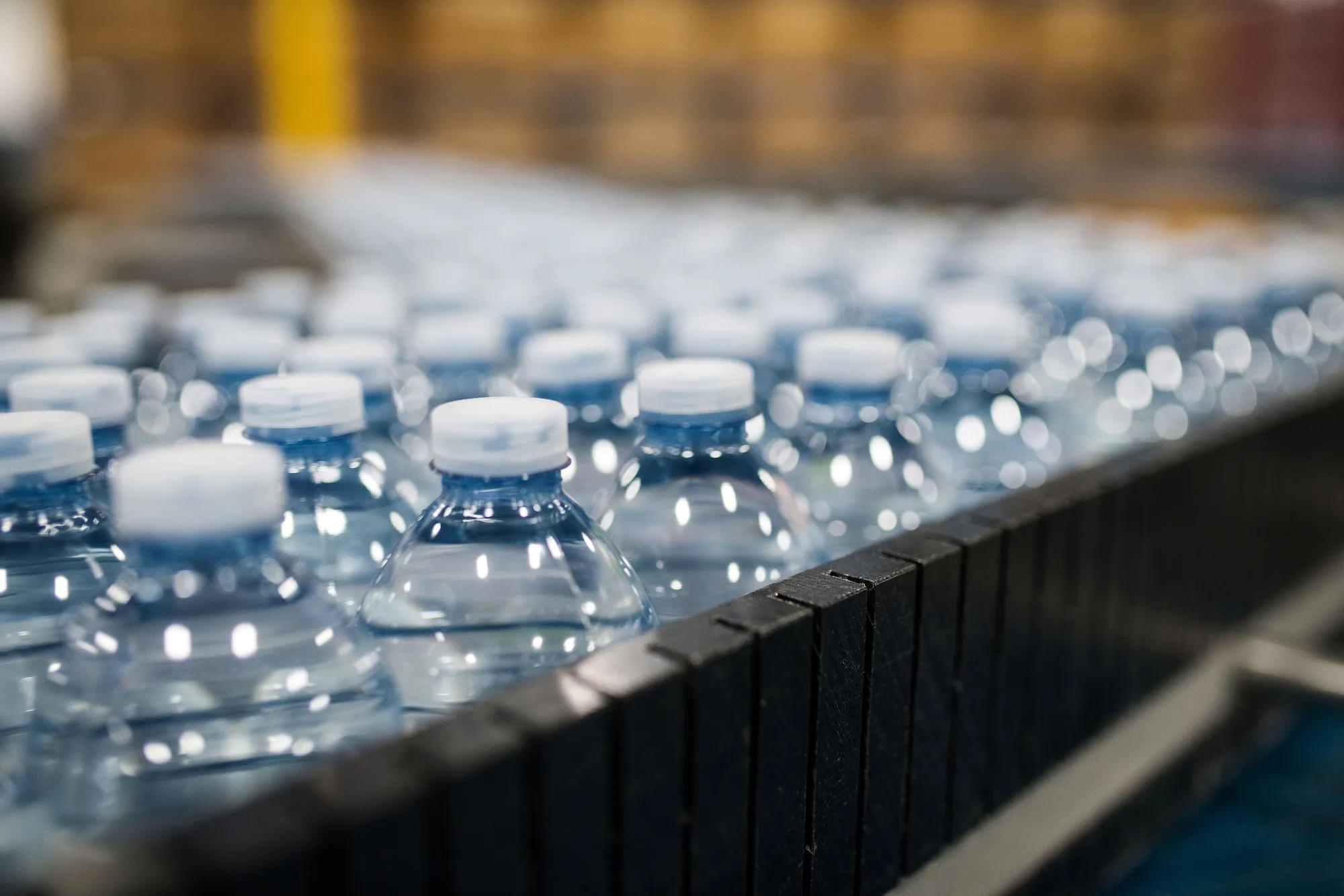 Plastic water bottles move along conveyors.
