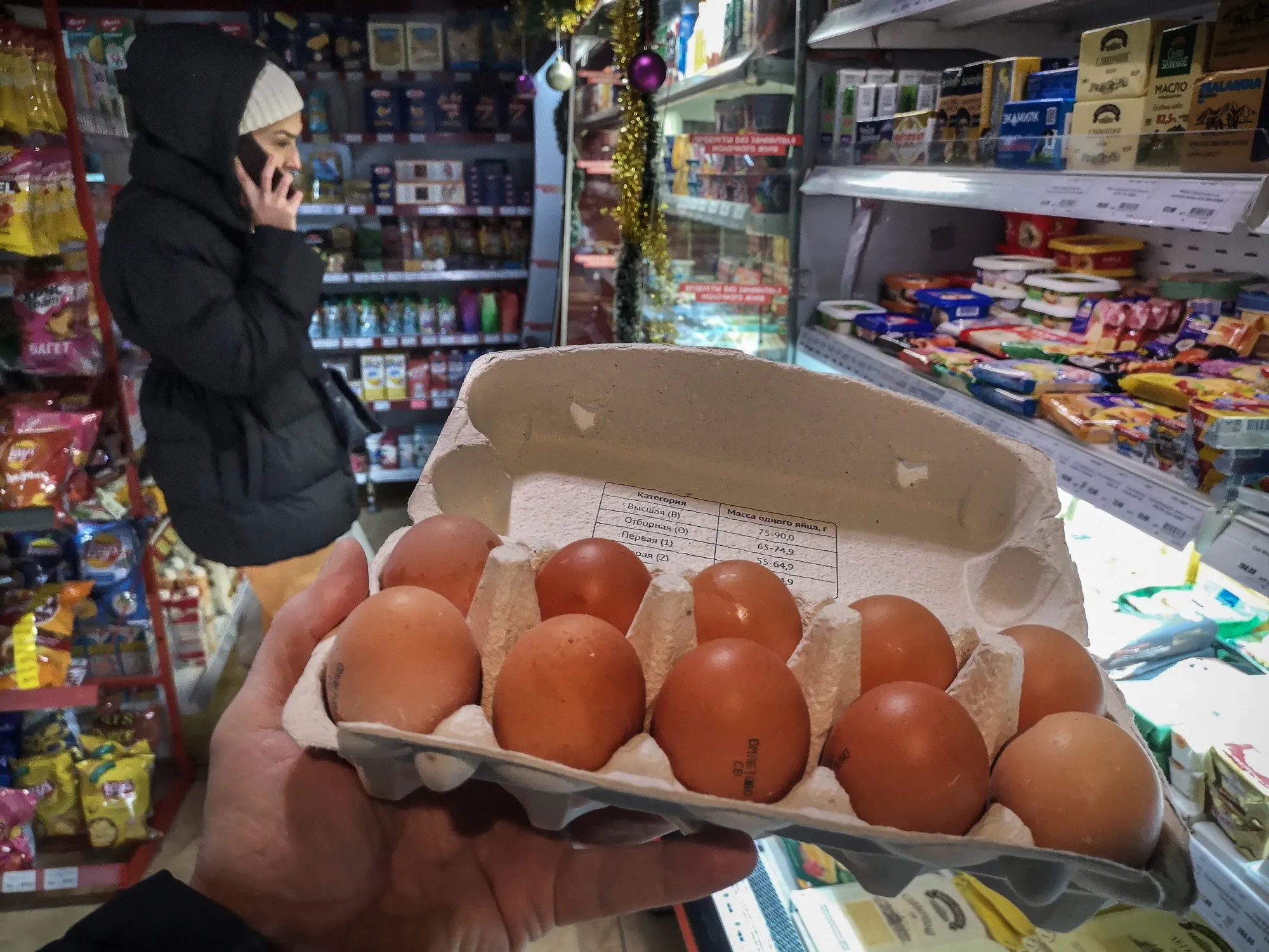 A customer holds a pack of chicken eggs in a shop in Moscow, Dec. 11.&nbsp;