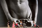 Shoppers walk past a billboard for a Abercrombie &amp; Fitch store in Singapore