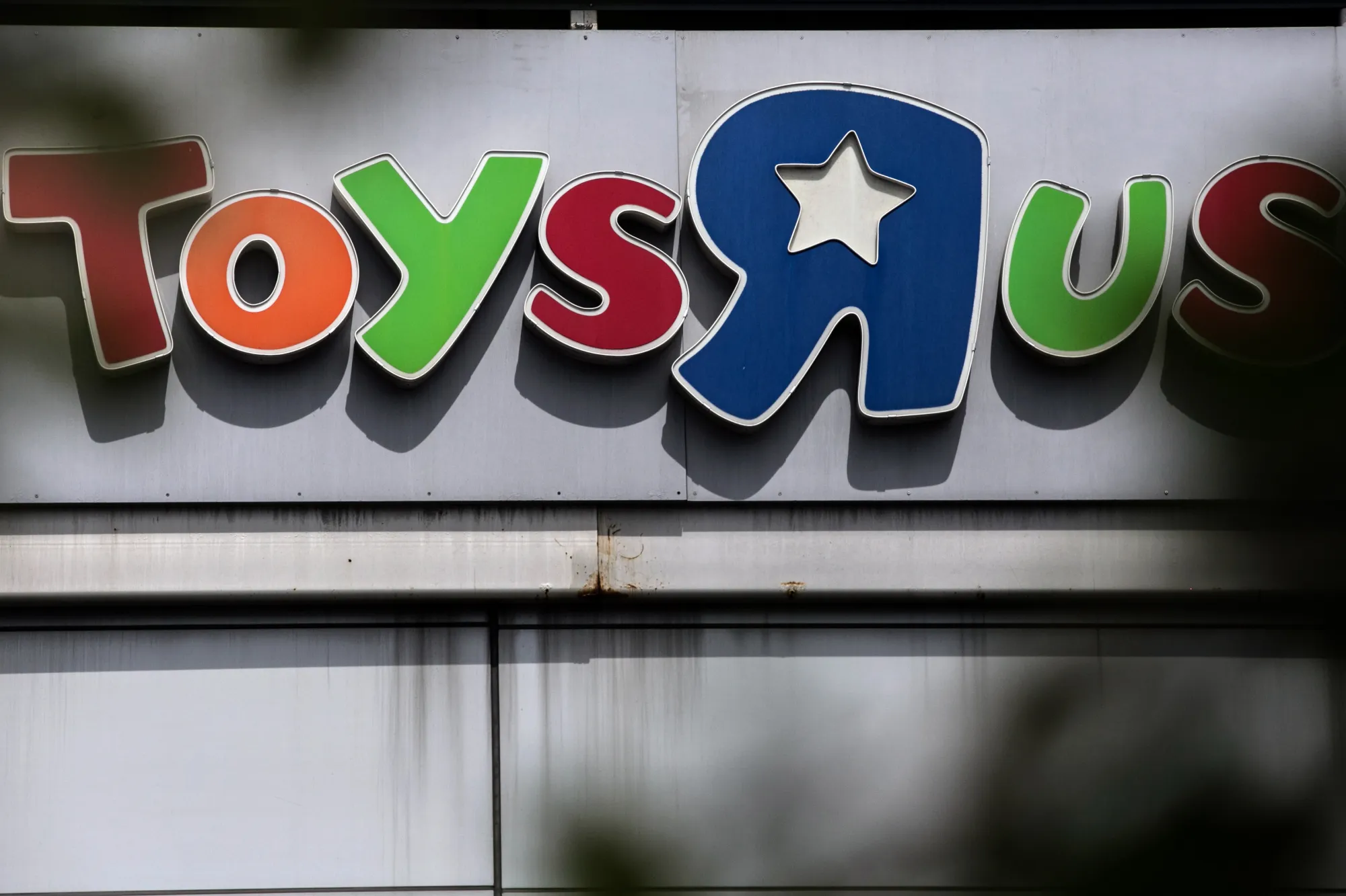 Signage is displayed on the exterior of a Toys 'R' Us retail store in the Queens borough of New York, U.S.