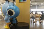 Employees sit at a table near an Ant Group Co. mascot displayed at the company's headquarters in Hangzhou, China, on&nbsp;Sept. 28.