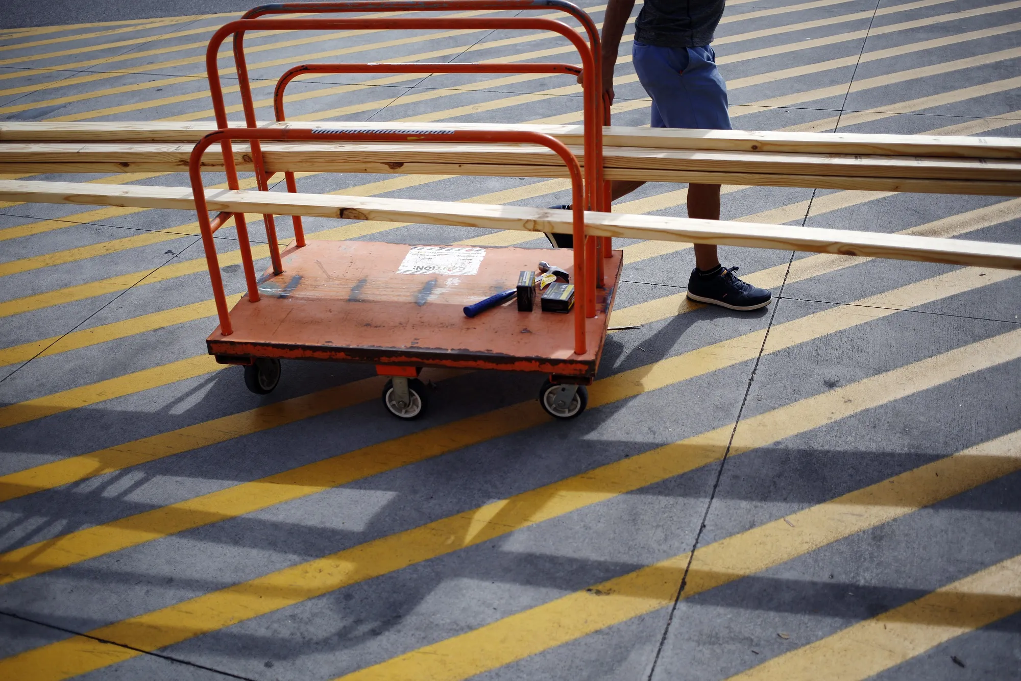 A customer pulls a cart of plywood outside a Home Depot Inc. store in Panama City Beach, Fla.