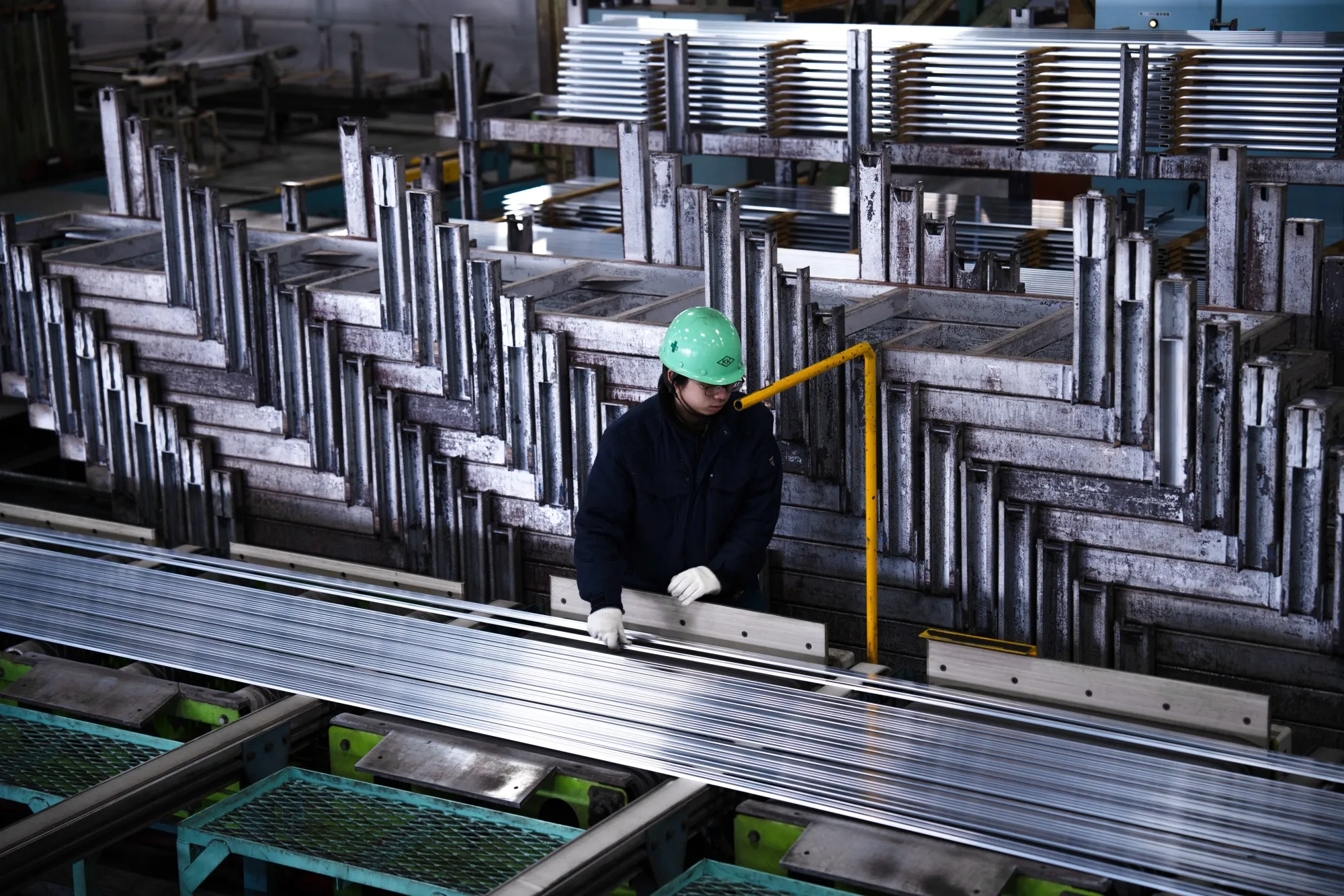 愛知県蟹江町の加藤軽金属工業の工場で、作業員がアルミ押出材を扱う様子