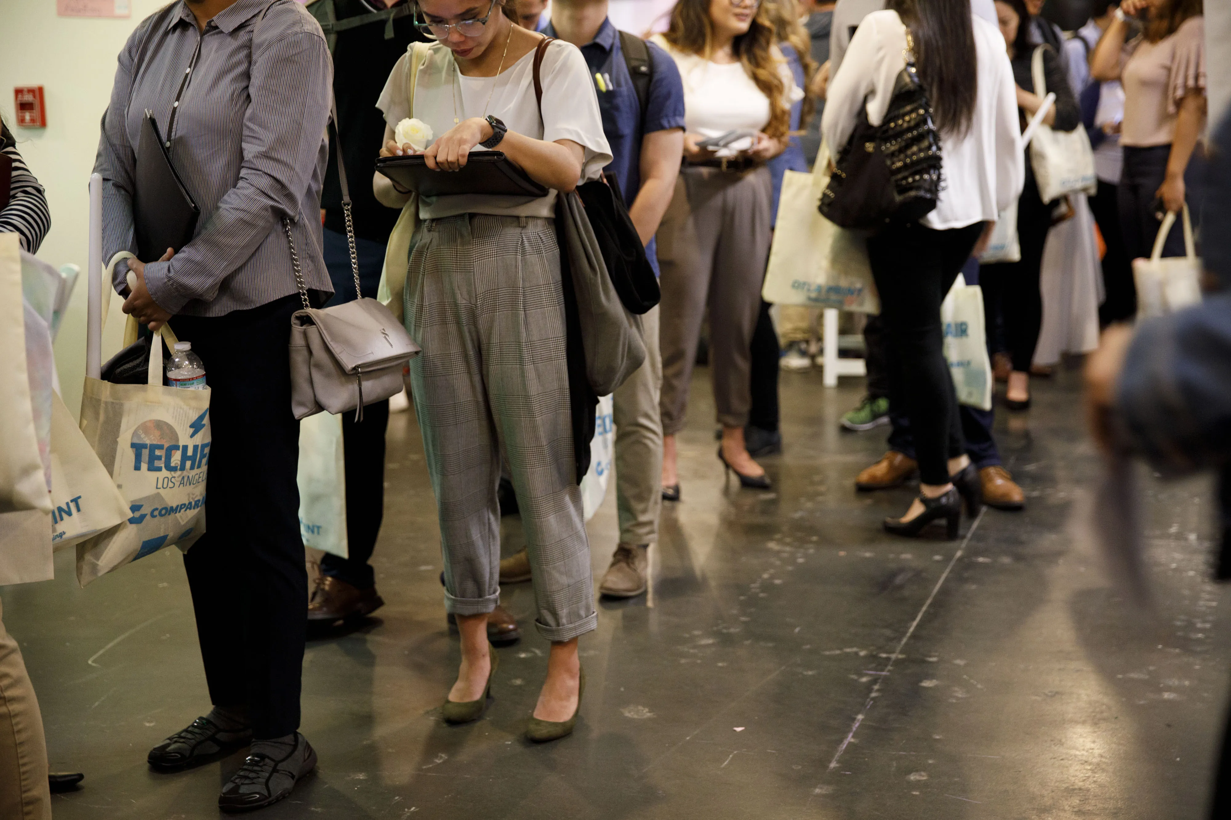 Job seekers wait in line to speak with representatives during a career fair in Los Angeles.