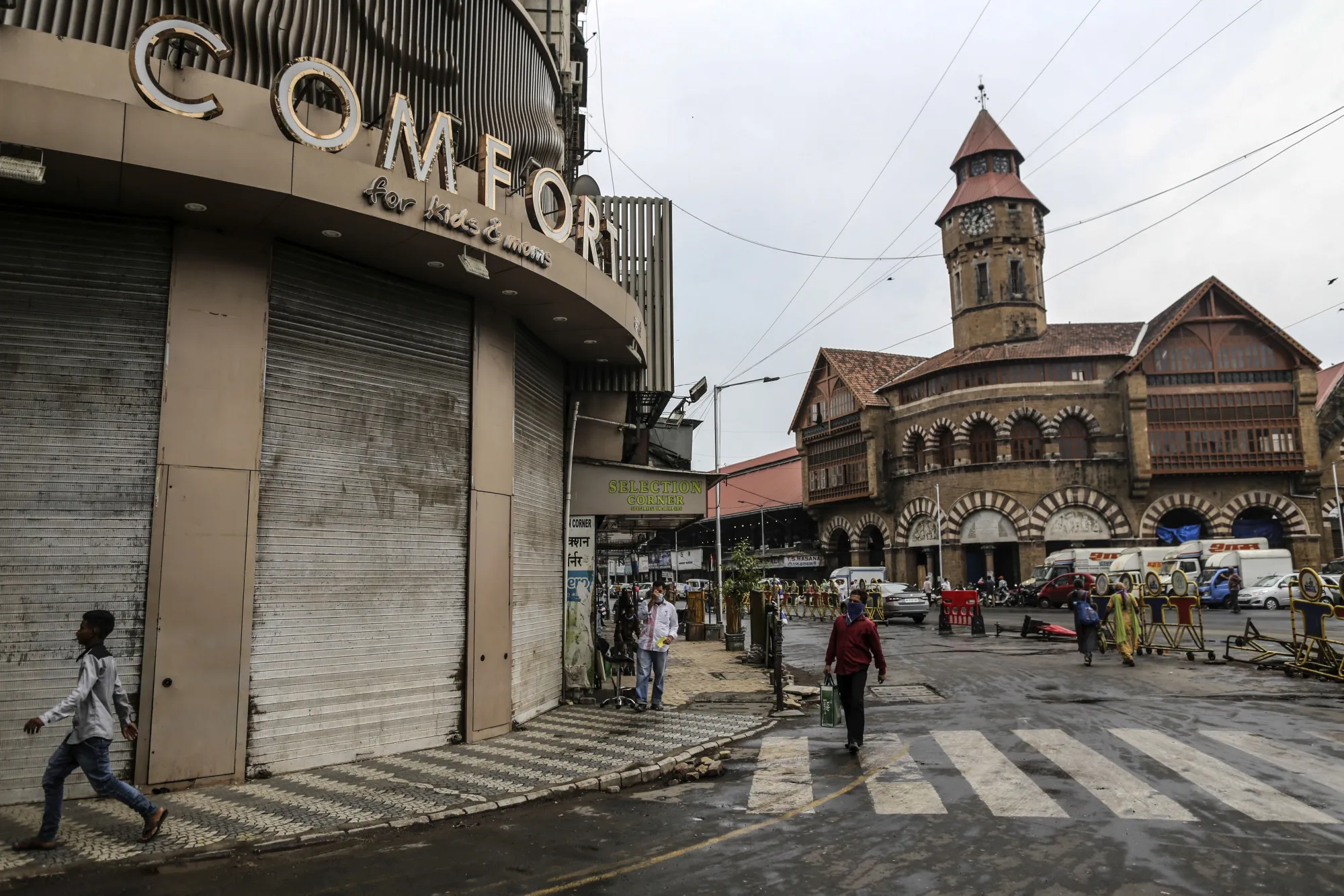 Pedestrians walk along a near-empty street near Crawford Market in Mumbai, June 2020.