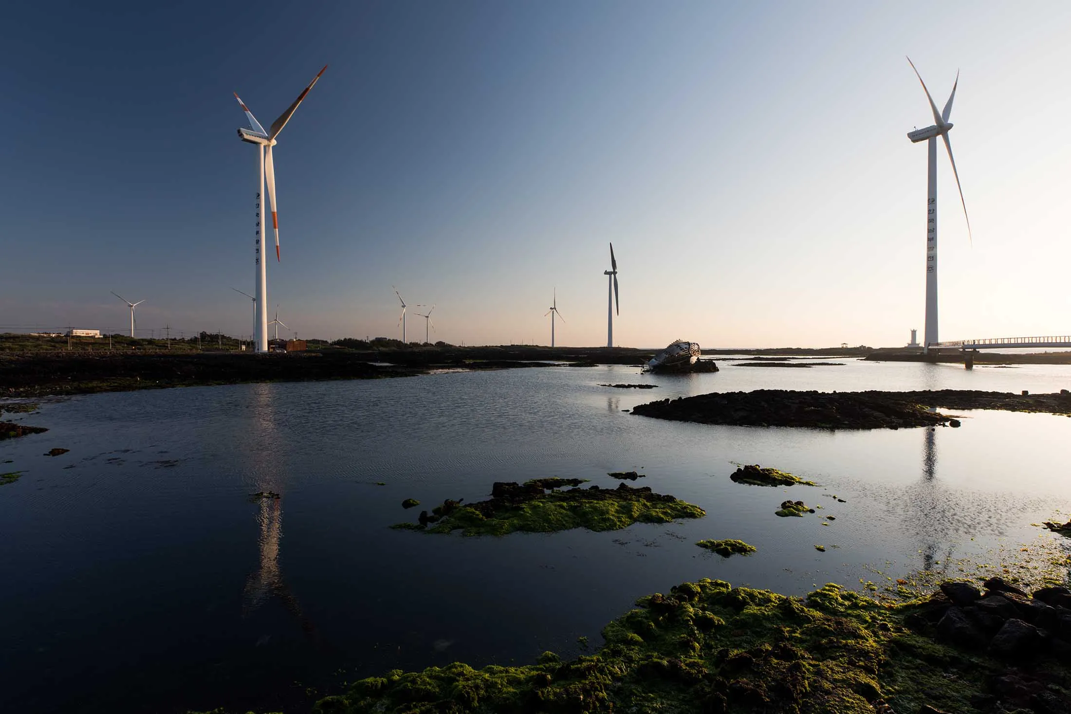Wind turbines stand at a wind farm in Jeju, South Korea, on Wednesday, June 14, 2017. The election of Moon Jae-in as South Korea’s new president implies a shift in the nation’s approach to energy, as he supports policies that favor natural gas and renewables at the expense of nuclear and coal, according to Bloomberg New Energy Finance.
