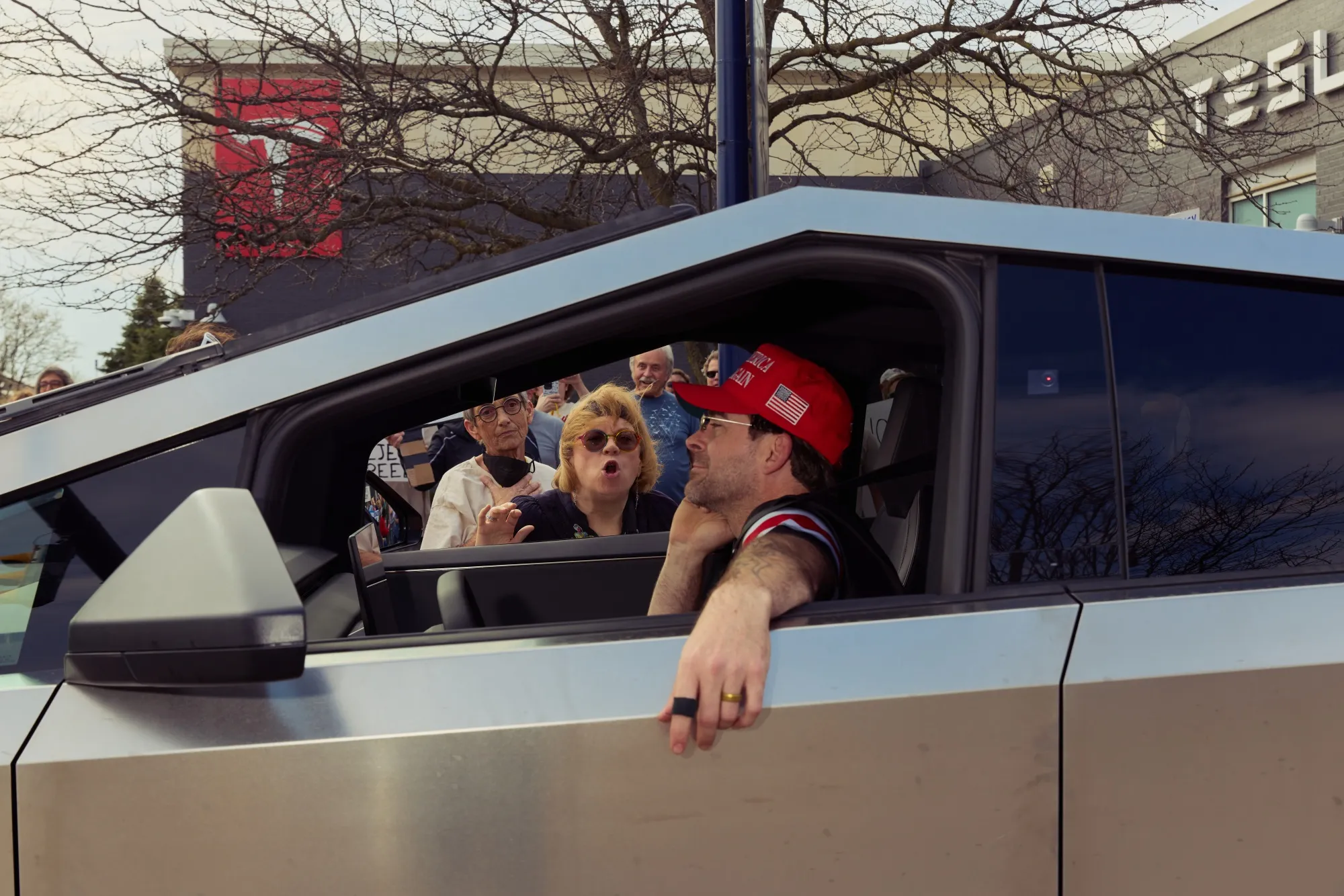A protester and a Tesla Cybertruck driver argue at a Tesla Takedown rally outside a Tesla showroom in Columbus, Ohio on&nbsp;March 29, 2025.&nbsp;