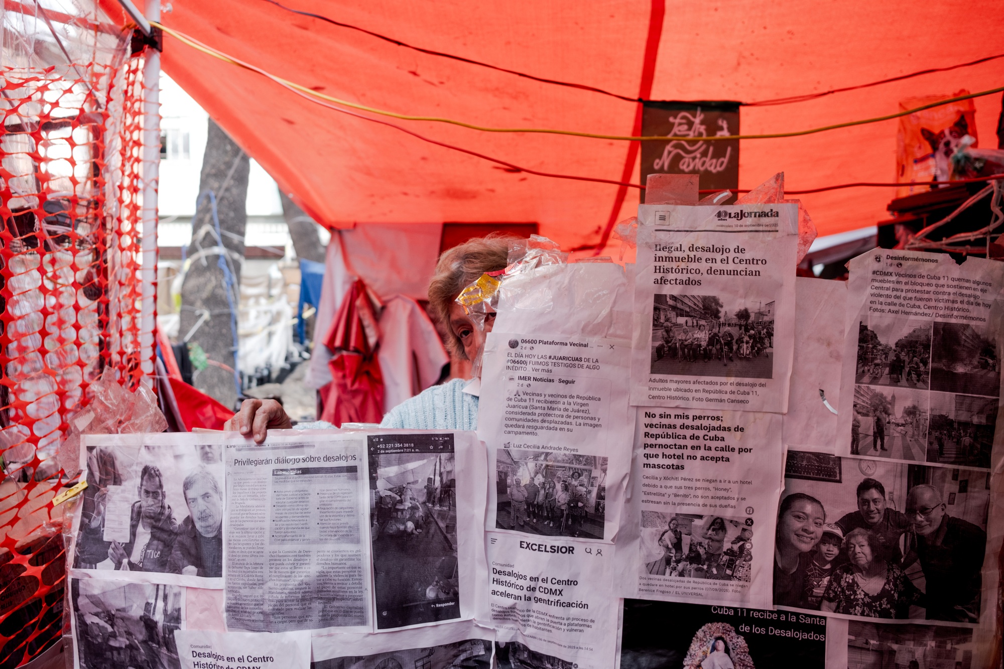 Lilia Pérez shows photocopies of local news articles published about the eviction on República de Cuba Street, at the improvised camp in Mexico City's historic center on Nov. 28, 2025. Around 20 families were evicted from a building on República de Cuba Street in Mexico City's historic center, a case that reflects how displacement is reshaping neighborhoods amid the city's accelerating gentrification. Fred Ramos for Bloomberg Photographer: FRED RAMOS/Bloomberg