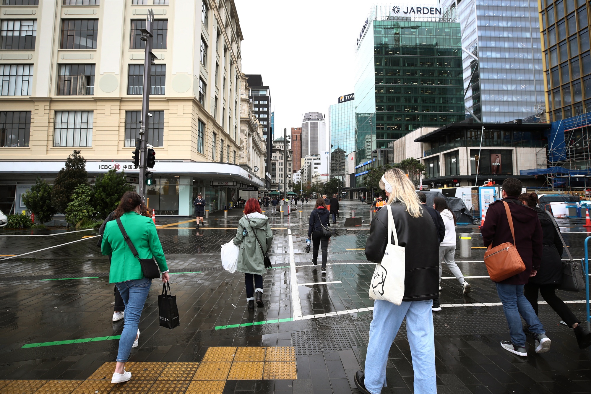 Pedestrians cross a road in Auckland, New Zealand.