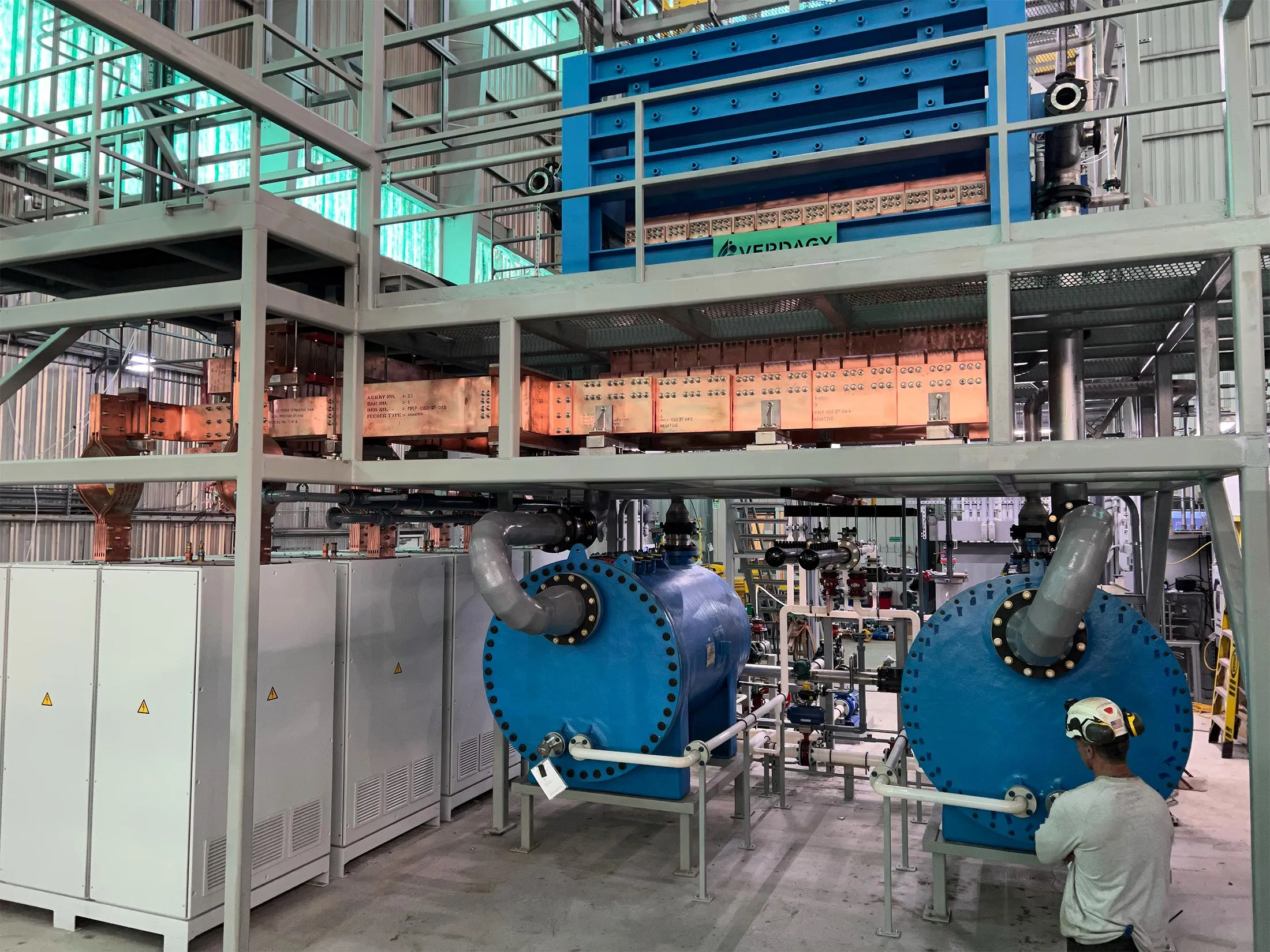 An electrolyzer in Verdagy’s pilot plant in Moss Landing, California. The electrolyzer’s cells are contained in the blue structure at top, while the cylindrical tanks hold electrolyte.