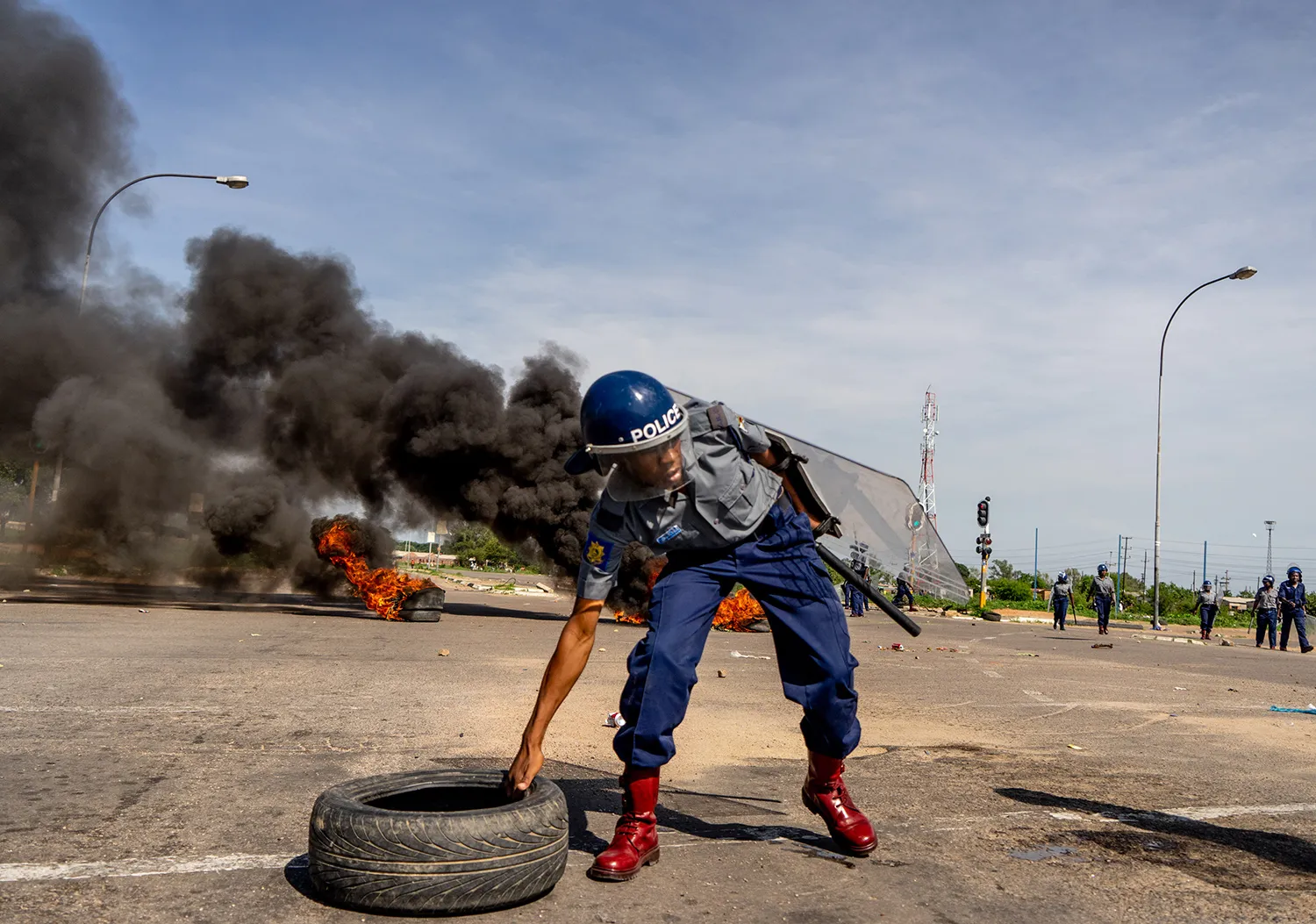 Police remove tires during a protest in Emakhandeni township, Bulawayo, on Jan. 14.