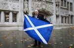 A Scottish independence supporter holds a Scottish national flag outside the Supreme Court in London, on Nov. 23.