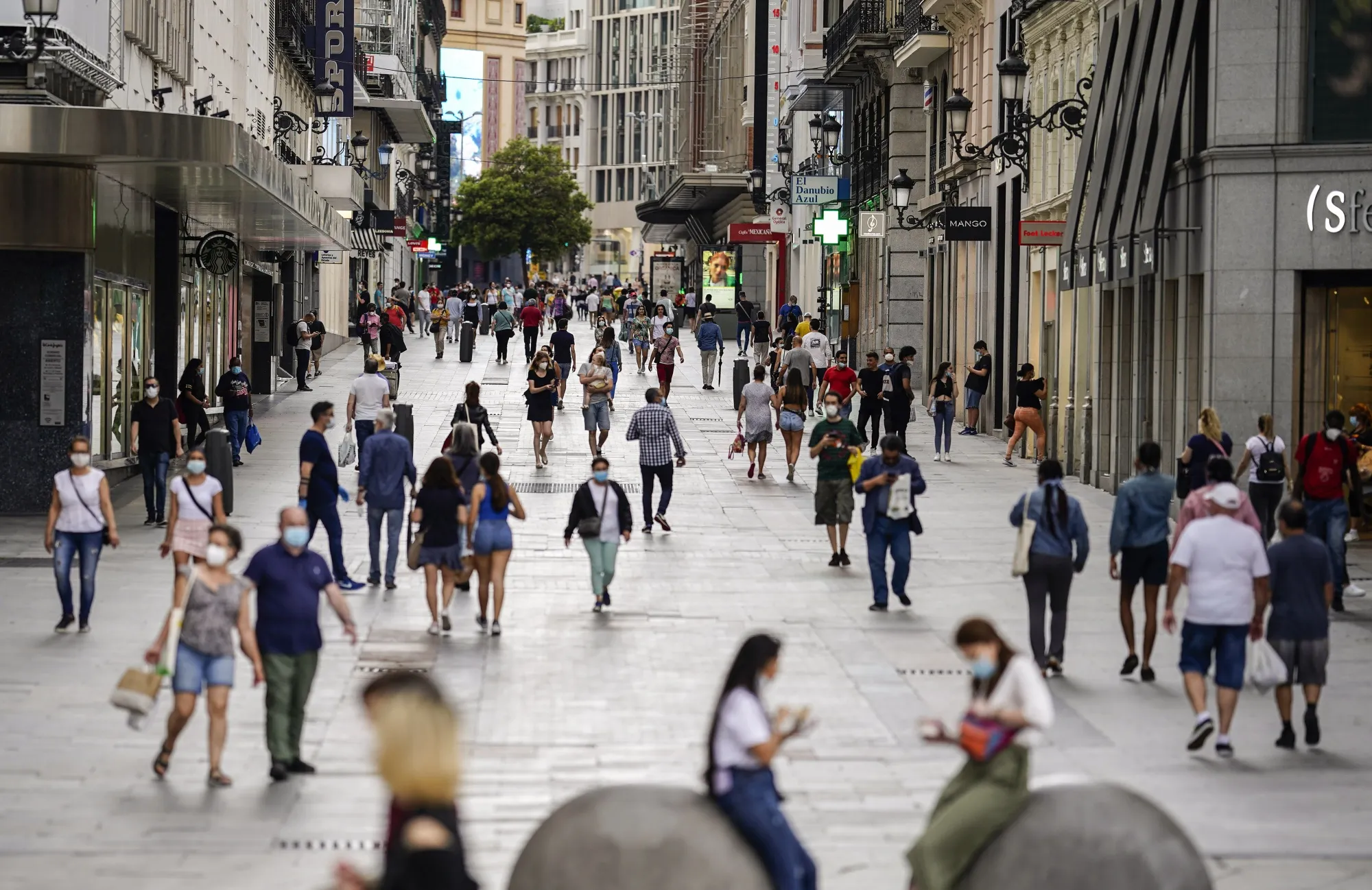 People&nbsp;walk along a pedestrianized shopping street&nbsp;in Madrid on May 25.
