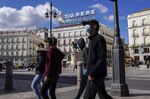 Pedestrians wearing protective masks walk through Puerta del Sol square in Madrid, Oct. 2.