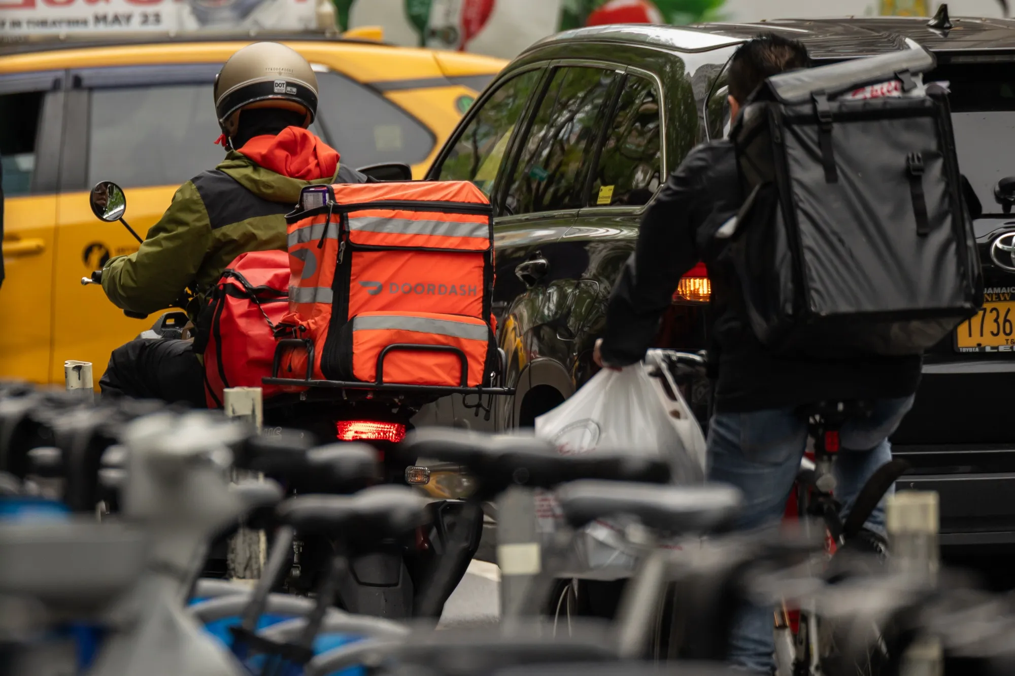 A delivery worker carries a DoorDash bag in New York.